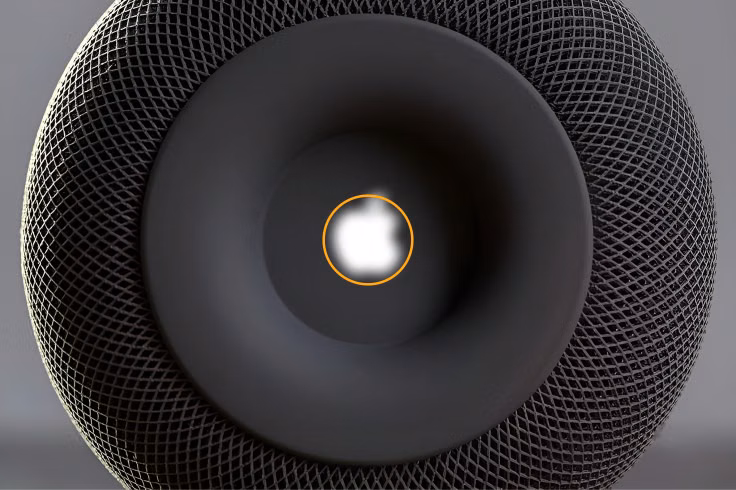 Blurred Apple logo mass aligned inside an orange center circle on the HomePod